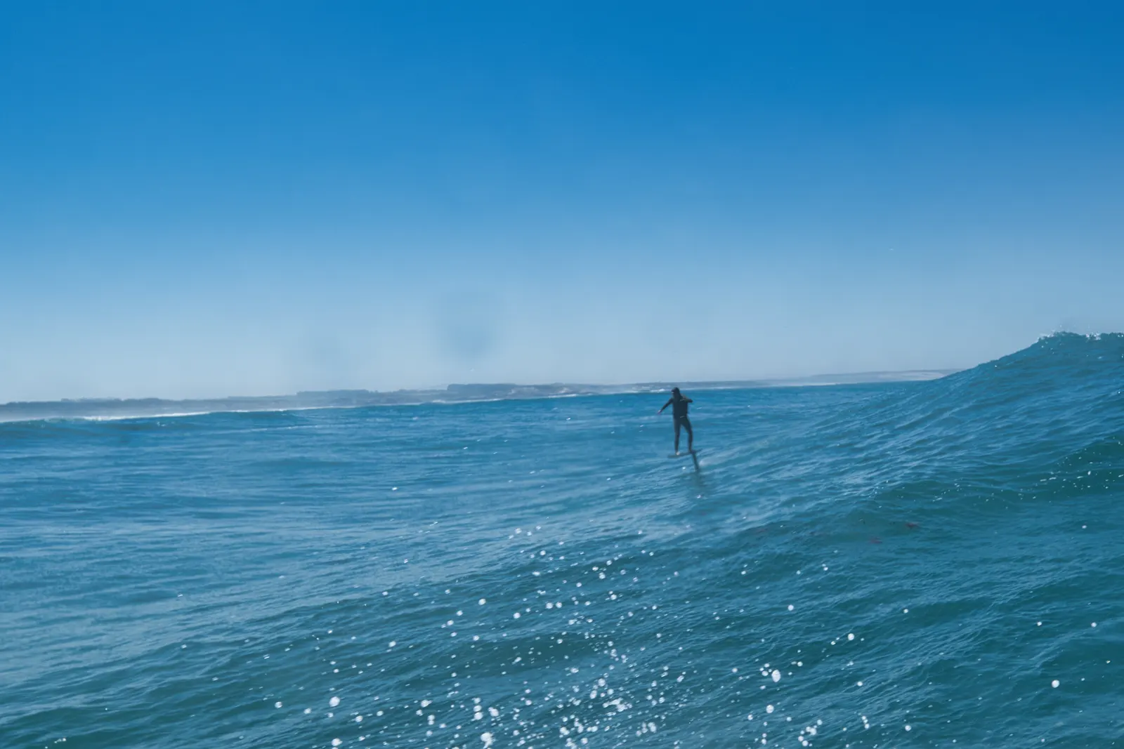 Foiler alone on a long open wave face